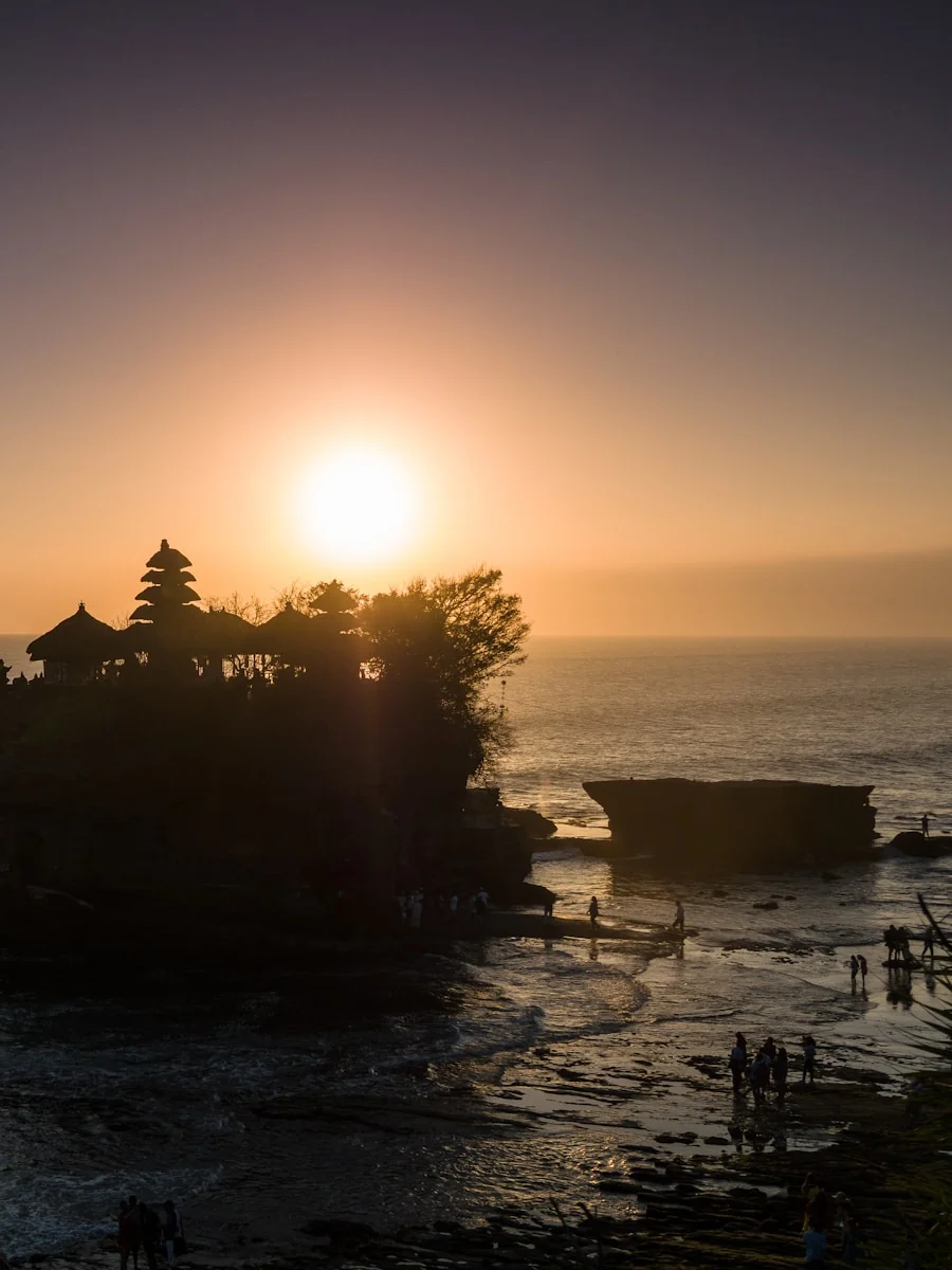 Tanah Lot Temple silhouetted against a warm Bali sunset