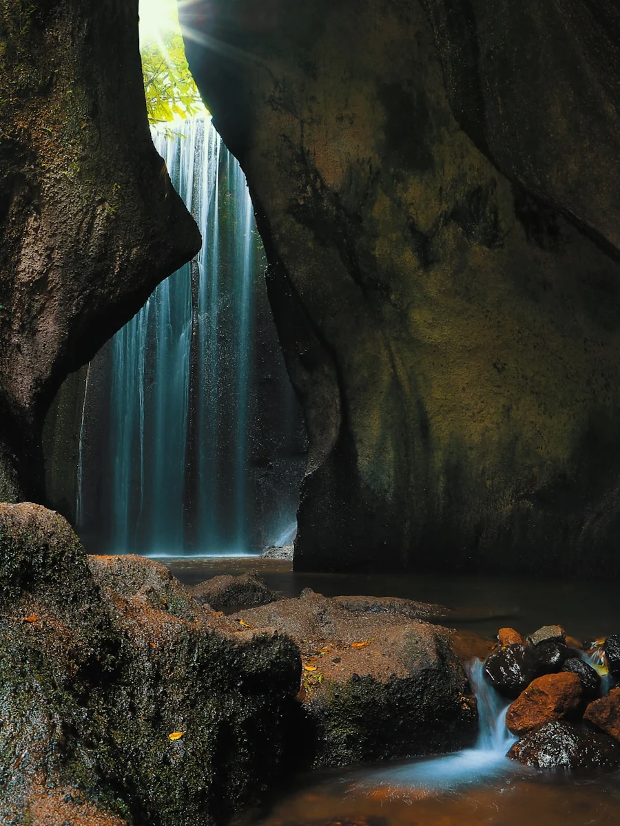 Tukad Cepung Waterfall flowing through a dramatic rock canyon in Bali